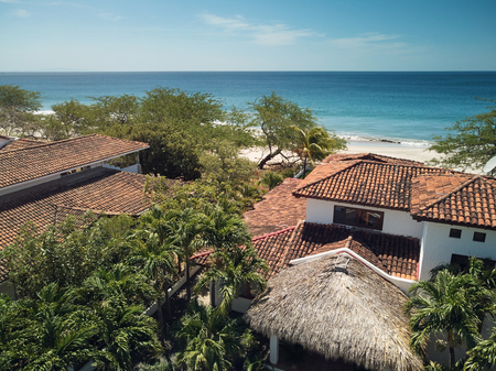 Vacation on beach theme. Roof of villa houses on blue sea backgroundの写真素材