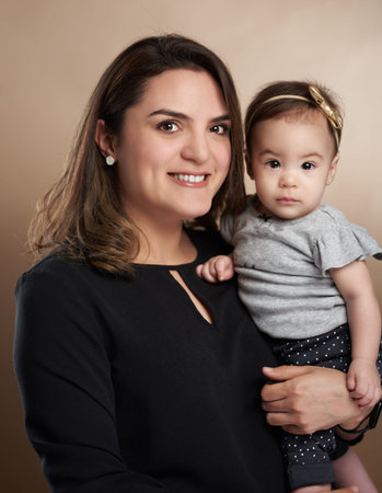 Mom holding toddler girl in studio brown color backgroundの写真素材