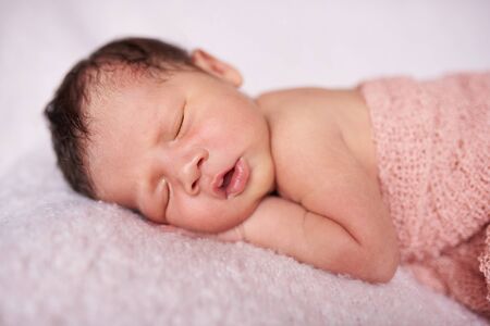 Cute newborn baby girl sleeping on soft blanketの写真素材