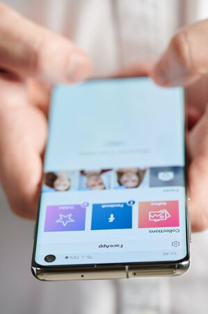New york, USA - july 22, 2019: Using faceapp mobile app close up view, smartphone in handsのeditorial素材