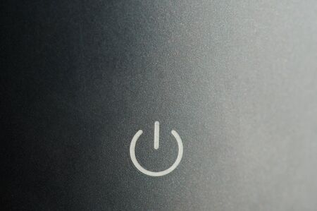 Power button on grey metal background macro close up viewの写真素材