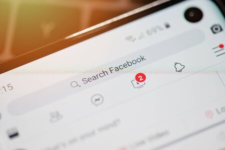 New york, USA - september 12, 2019: Search on facebook bar on smartphone screen close up viewのeditorial素材