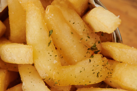 Brown salty french fries with herbs macro close up viewの写真素材