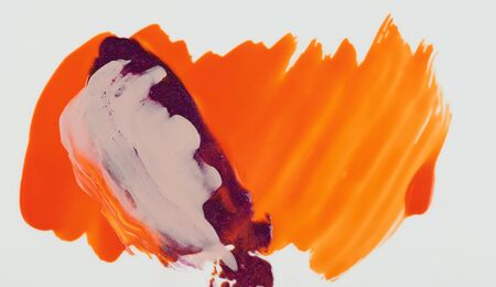 Mixed paint on orange color background close up viewの写真素材