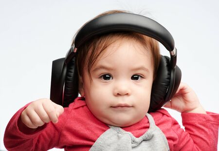 Baby girl with headphones close up  portrait isolated on white studio backgroundの写真素材