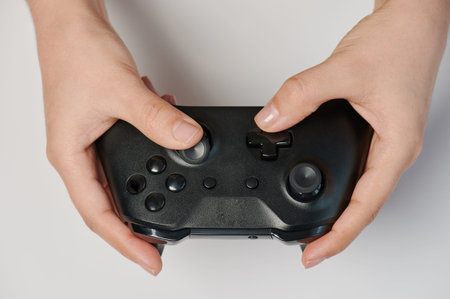 Black game controller in hand close up view isolated