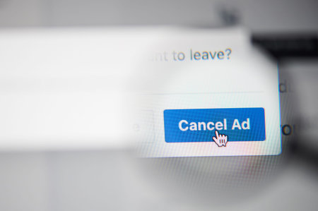 New-York , USA - March 13, 2020: Cancel ad in social media on laptop close up view throw magnifier