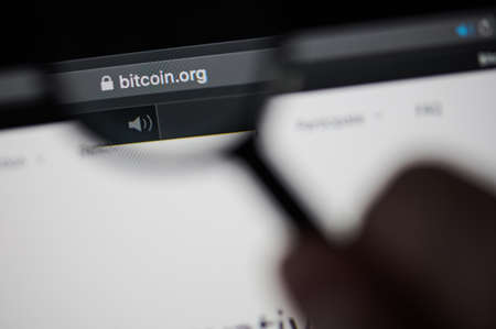 New-York , USA - March 13, 2020: Bitcoin currency official webpage view throw magnifier  close upのeditorial素材