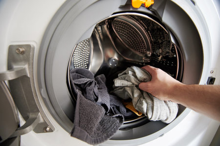 Loading washing machine theme. Hand put dirty cloth