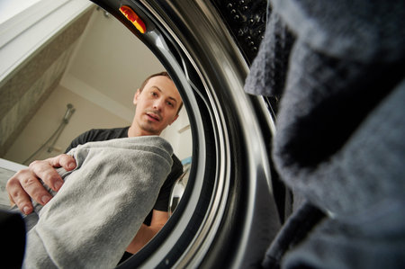 Man loading washing maching view from inside