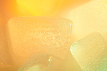 Orange color ice cube macro close up view. Abstract background