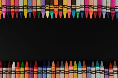 Colorful crayons boarder on black background copy spaceの写真素材
