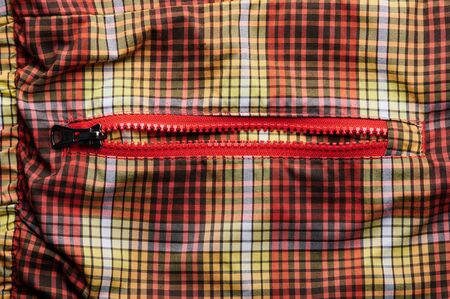 Open pocket with  zipper on orange and red fabric backgroundの写真素材