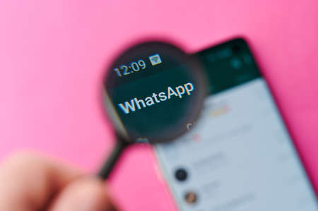 New-York , USA - June 4 , 2020: Using whatsapp app on modern smartphone throw magnifier close up viewのeditorial素材