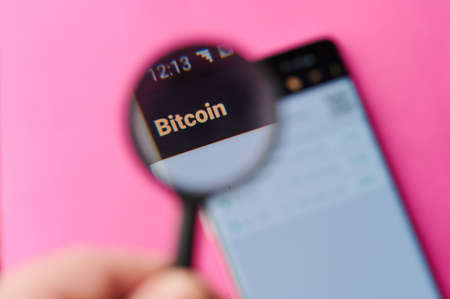 New-York , USA - June 4 , 2020: Using Bitcoin app on modern smartphone throw magnifier close up viewのeditorial素材