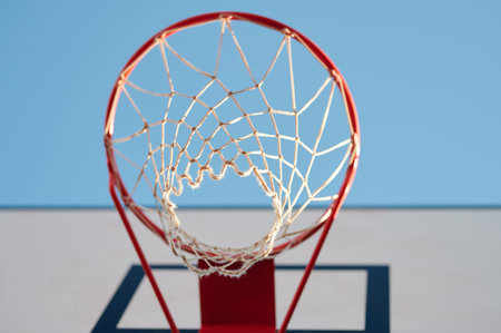 Basketball net on red ring bottom view in blue sky background