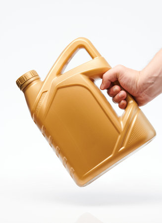 Yellow canister for oil in hand isolated close up viewの写真素材