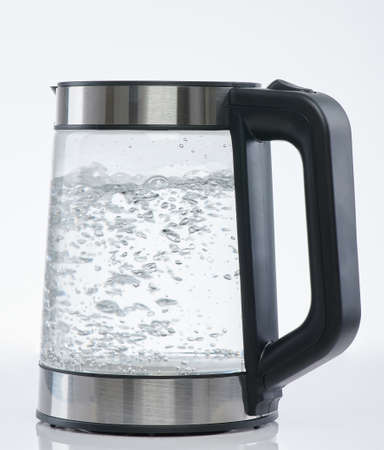 Water boiling in electric pot isolated on white studio backgroundの写真素材