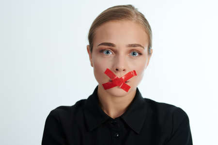 Crying woman portrait with shut mouth on white studio backgroundの写真素材