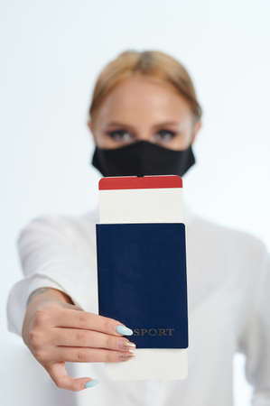 Passport with ticket pass in hand on blurred woman backgroundの写真素材