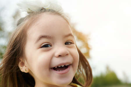 Portrait of happy wide smile baby girl on natural blurred backgroundの写真素材