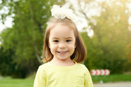 Portrait of happy kid girl on green park background