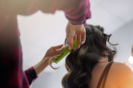 Comb hair of brunette woman in professional salon close up viewの写真素材