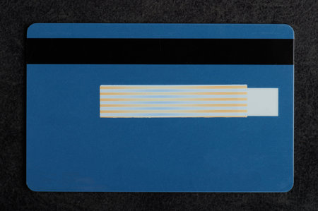 Blue debit card with space for signature and black magnet line
