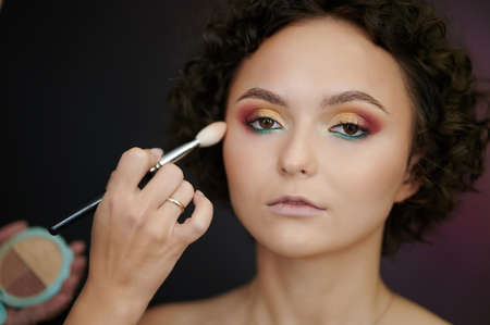 Applying make up on skin of caucasian young womanの写真素材