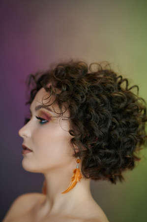 Profile portrait of young woman on green and purple backgroundの写真素材