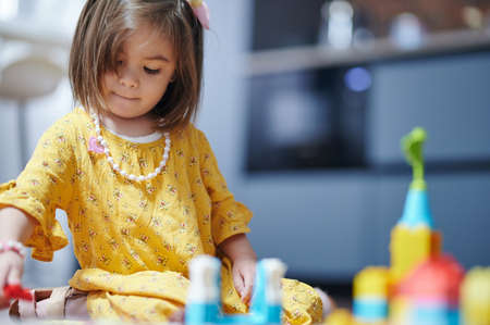 One girl play with colorful bricks on house room background with copy spaceの写真素材