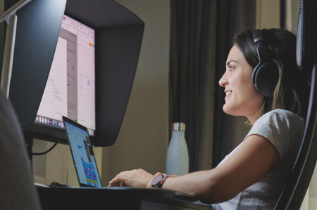 Smiling young woman with headphones in work at home
