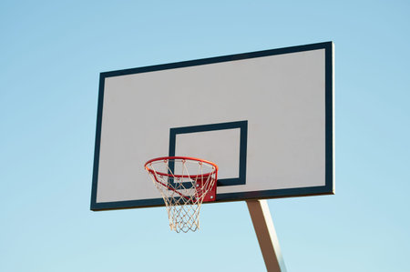 New basketball board with basket on blue sky background