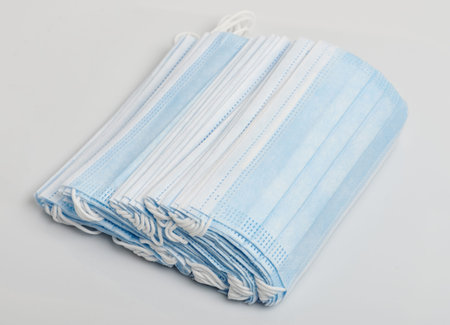 Pile of blue cotton face mask isolated on studio background