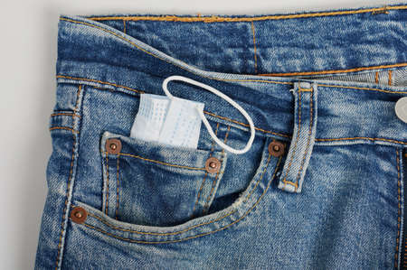 Face mask in front pocket of jeans macro close up viewの写真素材