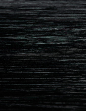Black brushed steel background macro close up view with selective focus