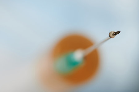 Drop on syringe needle macro close up view on blurred backgroundの写真素材