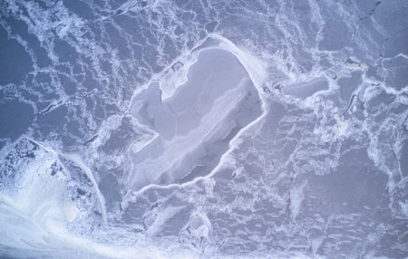 Frozen lake background above top view. Abstract pattern of ice