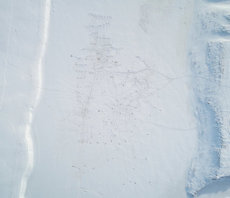 Frozen river with fisher holes aerial above drone top viewの写真素材