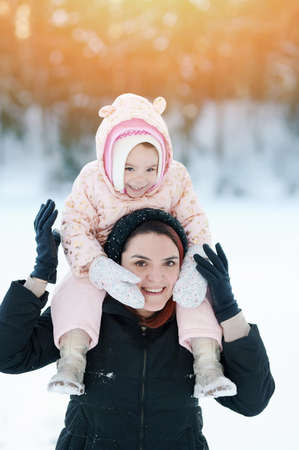 Smiling mom with kid portrait on sunny winter backgroundの写真素材