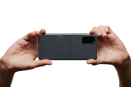 Take photo with mobile camera in two woman hands isolated on white studio backgroundの写真素材