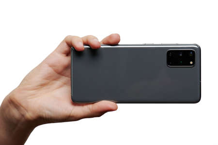 Taking photo with samrtphone in hand isolated on white studio backgroundの写真素材