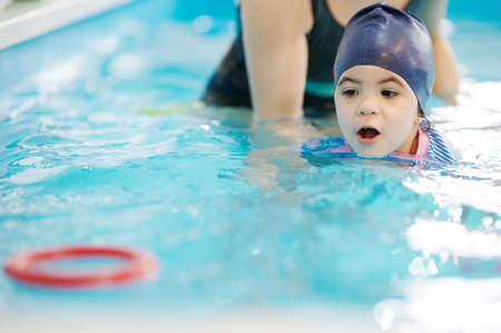 Kid learning to float in swimming pool. Child complete swimming exerciseの写真素材