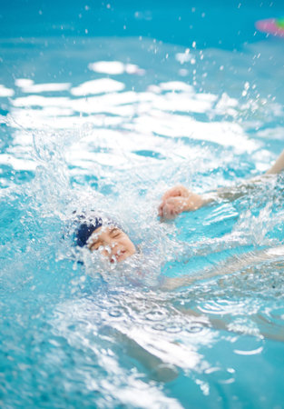 Small kid learn to dive in pool.  Kid drowning in pool water backgroundの写真素材