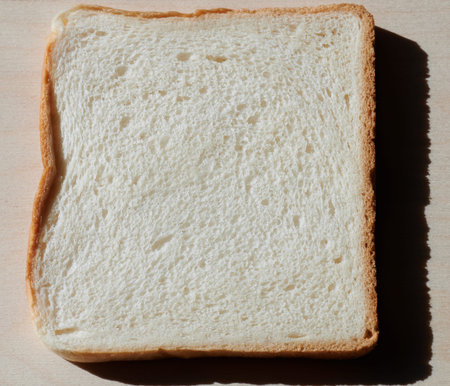Piece of white bread lay on desk flat view with shadow