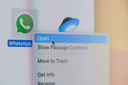 New york, USA - April 19, 2021: Click and open whatsapp messenger app on laptop screen macro close...
