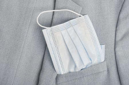 Cotton face mask in pocket of grey jacket close up viewの写真素材