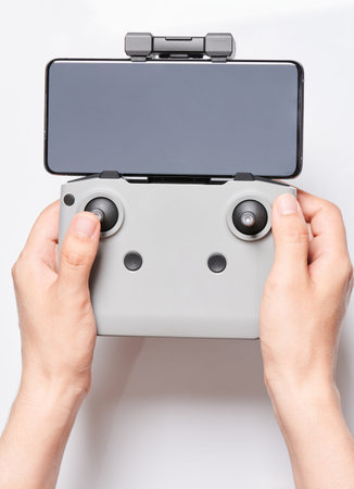 Control drone theme. Remote with smartphone in hands isolated