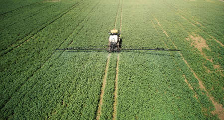 Farmer spray pesticides on crops aerial perspective drone viewの写真素材