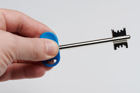 Long metal door key in hand close up view isolatedの写真素材